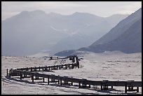 Alaska Pipeline snaking below Arctic Brooks mountains in winter. Alaska, USA