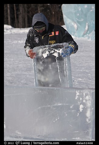 Ice carver lifting ice block. Fairbanks, Alaska, USA