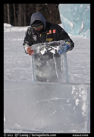 Ice carver lifting ice block. Fairbanks, Alaska, USA (color)