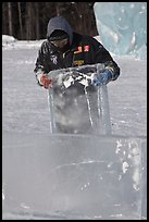 Ice carver lifting ice block. Fairbanks, Alaska, USA (color)