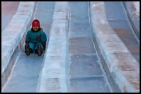 Girl on slide made of ice, George Horner Ice Park. Fairbanks, Alaska, USA