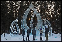 Tourists looking at ice sculpture, 2012 World Ice Art Championships. Fairbanks, Alaska, USA (color)