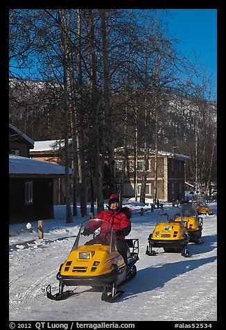 Snomobiler next to resort buildings. Chena Hot Springs, Alaska, USA