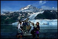 Kayakers unloading kayak from water taxi boat at Black Sand Beach. Prince William Sound, Alaska, USA