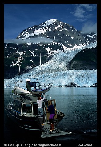 Kayakers unloading from the water taxi at Black Sand Beach. Prince William Sound, Alaska, USA (color)