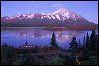 Mountains and lake at dusk, cabin with Denali sign. Alaska, USA