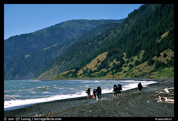Backpackers on black sand beach and King Range, Lost Coast. California, USA (color)