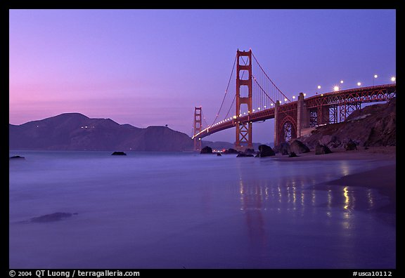 Golden Gage bridge at dusk, reflected in wet sand at East Baker Beach. San Francisco, California, USA