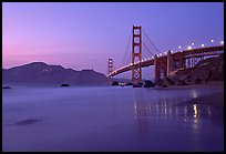 Golden Gage bridge at dusk, reflected in wet sand at East Baker Beach. San Francisco, California, USA (color)