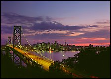 Bay Bridge and city skyline with lights at sunset. San Francisco, California, USA