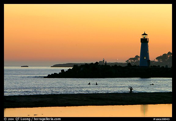 Lighthouse and Surfers in the water at sunset. Santa Cruz, California, USA (color)