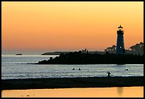 Lighthouse and Surfers in the water at sunset. Santa Cruz, California, USA (color)