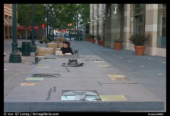 Woman sitting at a commemorative table in a downtown alley. San Jose, California, USA