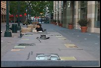 Woman sitting at a commemorative table in a downtown alley. San Jose, California, USA