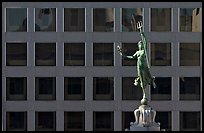 Statue on Admiral Dewey memorial column in front of modern building. San Francisco, California, USA