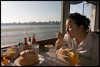 Woman eating clam chowder in a sourdough bread bowl. Santa Cruz, California, USA