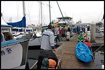 Pier with passengers preparing to board a tour boat with outdoor gear, Ventura. California, USA