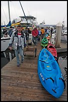 Sea kayaks and passengers awaiting loading on tour boat. California, USA