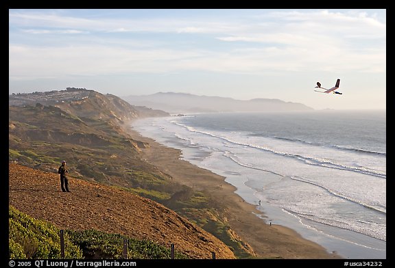 Man piloting model glider, Fort Funston, late afternoon. San Francisco, California, USA