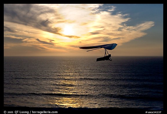 Soaring in a hang glider above the ocean at sunset,  Fort Funston. San Francisco, California, USA