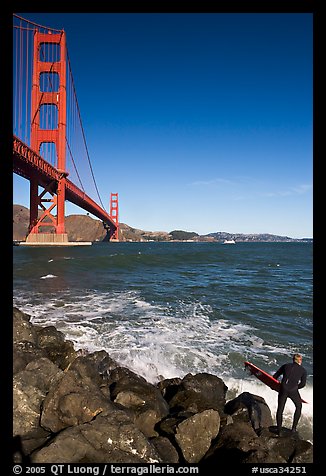 Surfer poised to jump in water below the Golden Gate Bridge. San Francisco, California, USA