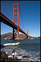 Surfer and wave below the Golden Gate Bridge. San Francisco, California, USA