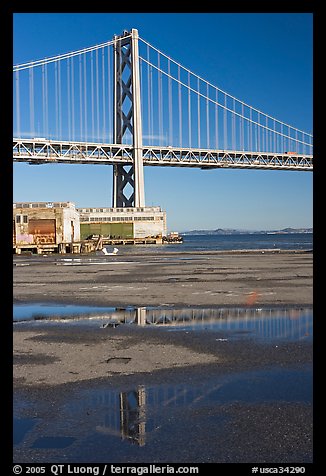 Bay Bridge reflected in water puddles. San Francisco, California, USA (color)