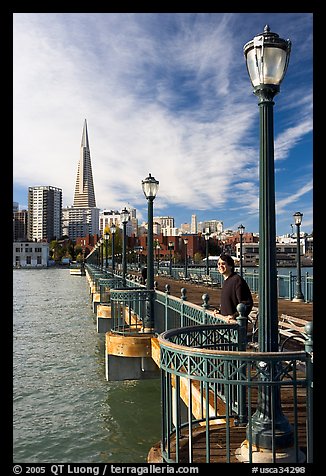 Visitor standing on pier 7, morning. San Francisco, California, USA