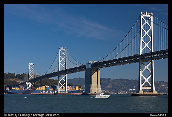 Cargo ship passing below the Bay Bridge. San Francisco, California, USA (color)