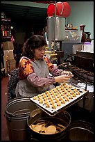 Woman folding fortune cookies, Chinatown. San Francisco, California, USA