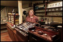 Woman standing behind counter of apothicary store, Old Town. San Diego, California, USA (color)