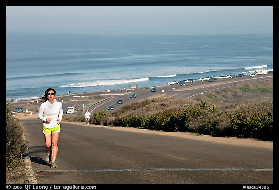 Woman jogging on raod,  Torrey Pines State Preserve. La Jolla, San Diego, California, USA