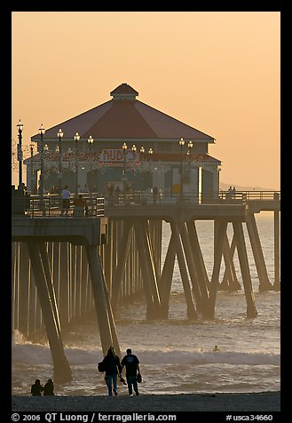 Beachgoers, surfers in waves,  and Huntington Pier. Huntington Beach, Orange County, California, USA (color)