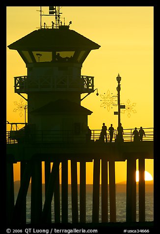 People and pier silhouetted by the setting sun. Huntington Beach, Orange County, California, USA (color)