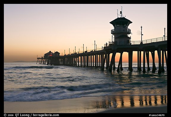 The 1853 ft Huntington Pier reflected in wet sand at sunset. Huntington Beach, Orange County, California, USA (color)