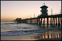 The 1853 ft Huntington Pier reflected in wet sand at sunset. Huntington Beach, Orange County, California, USA (color)