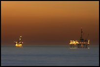 Oil drilling platforms lighted at dusk. Huntington Beach, Orange County, California, USA