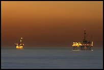 Oil drilling platforms lighted at dusk. Huntington Beach, Orange County, California, USA (color)