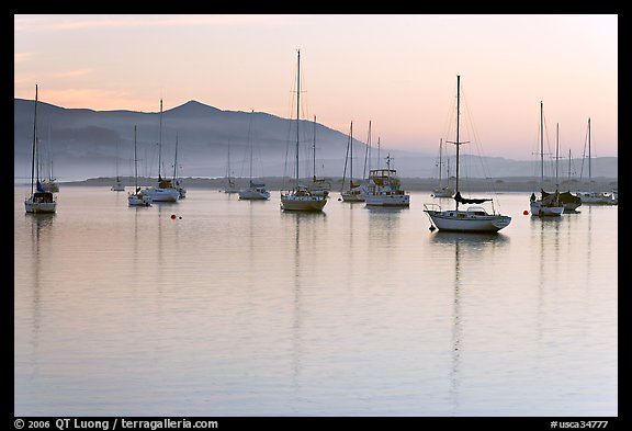 Yachts reflected in calm  Morro Bay harbor, sunset. Morro Bay, USA