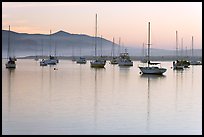 Yachts reflected in calm  Morro Bay harbor, sunset. Morro Bay, USA (color)