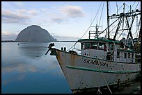Baat with rusted hull and Morro Rock. Morro Bay, USA