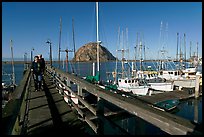 People walking on a deck in the harbor. Morro Bay, USA