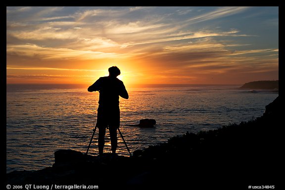 Photographer on cliffs at sunset. Santa Cruz, California, USA (color)
