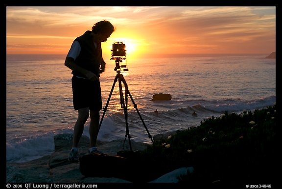 Photographer and large format camera on tripod at sunset. Santa Cruz, California, USA