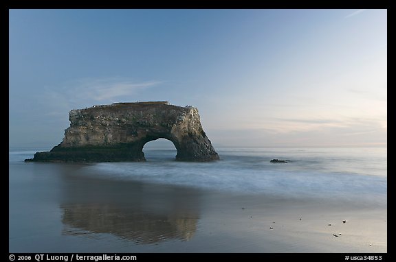 Sea arch and reflection, Natural Bridges State Park, dusk. Santa Cruz, California, USA