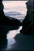 Reflection on wet sand through rock opening, Natural Bridges State Park, dusk. Santa Cruz, California, USA (color)