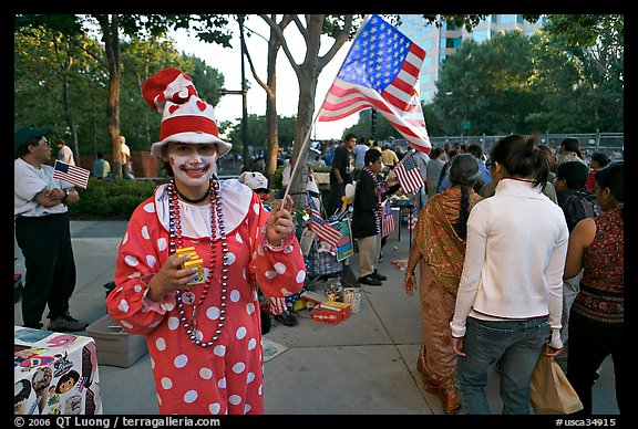 Woman in clown costume waiving American Flag, Independence Day. San Jose, California, USA (color)