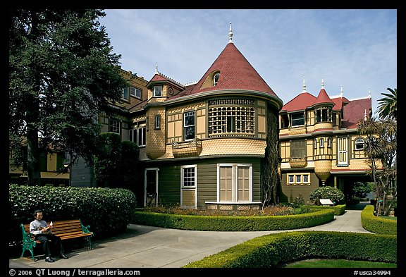 Woman reading on a bench in the gardens. Winchester Mystery House, San Jose, California, USA (color)