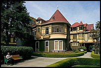 Woman reading on a bench in the gardens. Winchester Mystery House, San Jose, California, USA