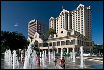 Children playing in fountain on Plaza de Cesar Chavez. San Jose, California, USA (color)